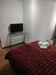 a bedroom with a bed with two pillows and a desk at Suites Casa Blanca Metepec in Toluca