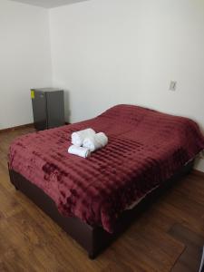 a bedroom with a bed with two towels on it at Suites Casa Blanca Metepec in Toluca +27 photos