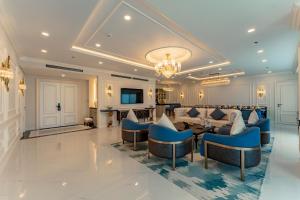 a living room with blue chairs and a couch at Cosmo Stars Hotel Bạc Liêu in Bạc Liêu