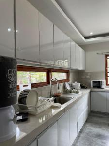 a kitchen with white cabinets and a sink at Norwil Manor Tagaytay in Tagaytay