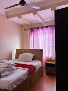 a bedroom with a bed and pink curtains at Hotel Syangbo Brothers in Kathmandu