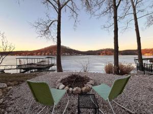 two chairs and a fire pit next to a lake at Lucky Duck Lakefront Fire Pit in Gravois Mills