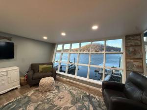 a living room with a large window with a view of the water at Lucky Duck Lakefront Fire Pit in Gravois Mills +36 photos