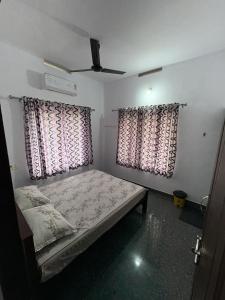 a bedroom with a bed and two windows at Anchery homes in Trichūr