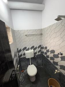 a bathroom with a toilet and a black and white wall at Anchery homes in Trichūr +3 photos