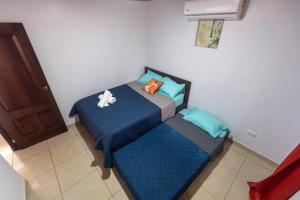 a small bedroom with a blue bed in a room at Villa Arenal Volcano & Privade pool in Fortuna +14 photos
