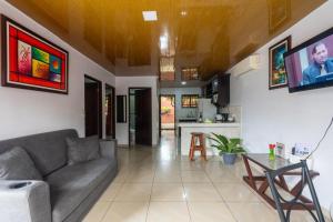 a living room with a couch and a kitchen at Villa Arenal Volcano & Privade pool in Fortuna