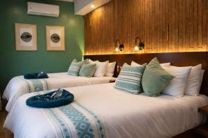 two beds in a hotel room with two bedsvisor at Hotel Boutique Casa Gopar in Ocotlán de Morelos +21 photos
