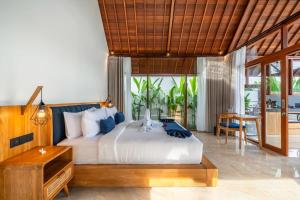 a bedroom with a bed and a desk and a table at Villa Apuh Rose in Ubud +41 photos