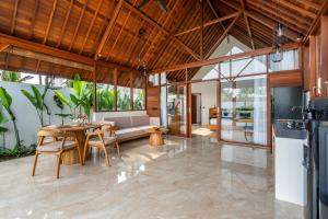 an open living room with a table and chairs at Villa Apuh Rose in Ubud