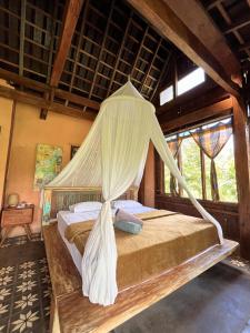 a bedroom with a bed with mosquito net at duegoal farmhouse in Jatiluwih
