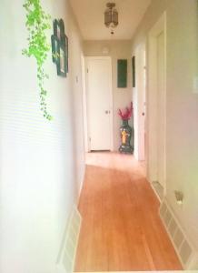 a hallway with white walls and a wooden floor at Bright Private Room near Montreal Fast WiFi in Brossard