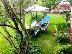 a patio with two chairs and an umbrella in a yard at Bright Private Room near Montreal Fast WiFi in Brossard +2 photos