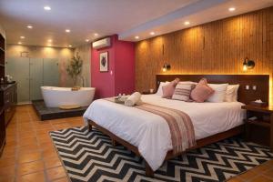 a bedroom with a large bed and a bath tub at Hotel Boutique Casa Gopar in Ocotlán de Morelos