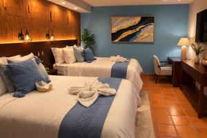 a hotel room with two beds with towels on them at Hotel Boutique Casa Gopar in Ocotlán de Morelos