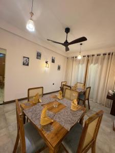 a dining room with a wooden table and chairs at Novara Haven Airport Transit Hotel in Katunayaka