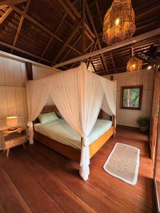a bedroom with a bed with a mosquito net at The Angkayo in Angkayo