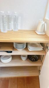 a wooden shelf with plates and water bottles at 父母ヶ浜リゾートヴィラ Senja in Mitoyo