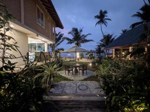 a patio with a table and chairs in front of a house at Beach Garden in Weligama