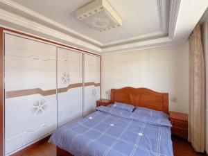 a bedroom with a bed with a blue comforter at 青云小栈 in Shaoxing