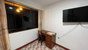 a room with a large window and a television on the wall at CATTLEYA Casa Hospedaje in Nueva Cajamarca