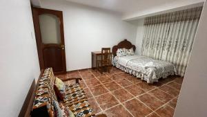 a bedroom with a bed and a tiled floor at CATTLEYA Casa Hospedaje in Nueva Cajamarca