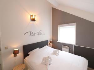 a bedroom with a white bed with a sign on the wall at Getaway with Bikes & Whirlpool in Grou