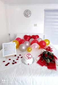 a table with a cake and balloons on a bed at Zoobic Glampz in Subic