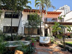 a house with a chair in a courtyard at CASA ALUNA Un refugio para desconectarte in Cuernavaca