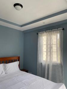 a bedroom with a white bed and a window at Anne's Emerald Tranquility Villas in Laborie