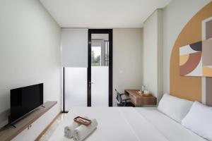a hotel room with a bed and a television at Cove Casa Dyna in Jakarta +6 photos