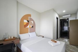 a bedroom with a large white bed and a desk at Cove Casa Dyna in Jakarta