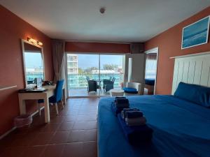 a hotel room with a bed and a table and chairs at GrandBlue Resort & Beachclub in Mae Pim