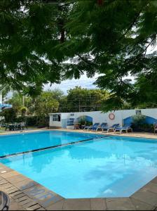 a large swimming pool with chairs and a building at Sunrise-Nyali, Mombasa in Nyali