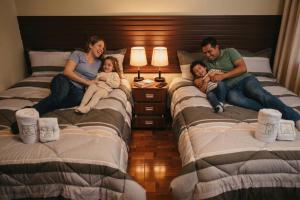 a group of people sitting on beds in a bedroom at Gran Hotel Real in Huancayo