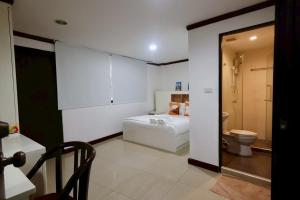 a white room with a bed and a toilet at Sampheng House in Bangkok