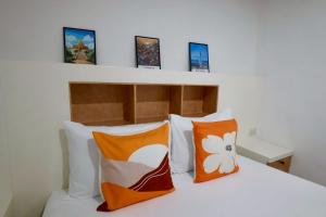 a bedroom with a bed with orange and white pillows at Sampheng House in Bangkok +105 photos
