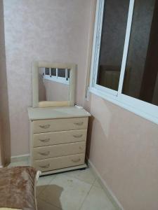 a dresser with a mirror and a window in a room at Appartement hay lmatar in Nador