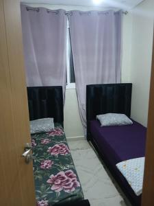 a room with two beds and a window with curtains at Appartement hay lmatar in Nador