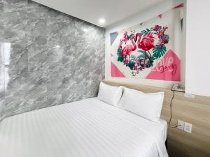 a bedroom with a white bed and a painting on the wall at Moana Hotel Nha Trang in Nha Trang +34 photos