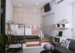 a bedroom with a bed and a desk with a laptop at Aparta Hotel Loft 1985 in Puerto Gaitán