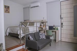 a bedroom with a bed and a couch and a chair at Aparta Hotel Loft 1985 in Puerto Gaitán