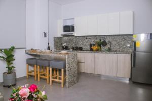 a kitchen with a counter and a refrigerator at Aparta Hotel Loft 1985 in Puerto Gaitán
