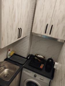 a small bathroom with a washing machine and a sink at Garsoniera P2 in Craiova