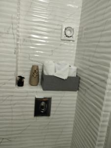a bathroom with a shelf with towels on a wall at Garsoniera P2 in Craiova +5 photos