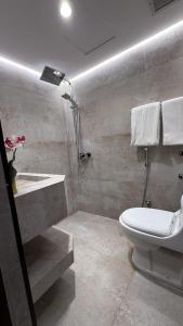 a bathroom with a shower and a toilet and a sink at جناح خاص في أجنحة طيبة مكارم in Medina +8 photos
