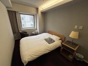 a hotel room with a bed and a window at Hotel Tetora Spirit Sapporo in Sapporo +22 photos