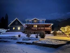 a house with christmas lights on it in the snow at Mountain Guesthouse Bed and Baking in Radium Hot Springs