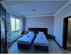 a bedroom with two beds and a window at Sunrise-Nyali, Mombasa in Nyali +20 photos