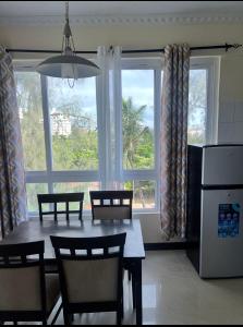 a kitchen with a table and chairs and a window at Sunrise-Nyali, Mombasa in Nyali